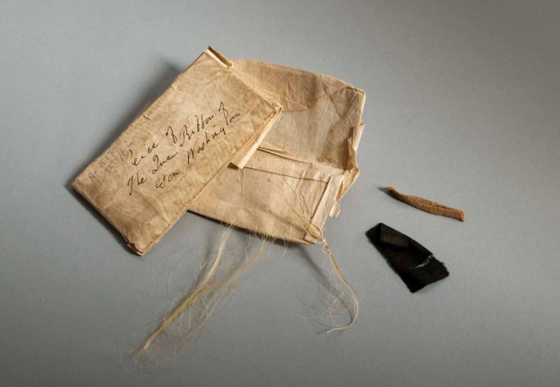 Ribbon and linen fragments with lock of George Washington's hair
Silk, linen, hair, paper
176 ...